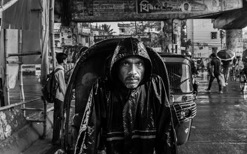 Black and White Photo of a Man Wearing a Raincoat