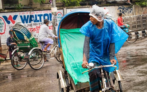 A Man Driving Tricycle During Rainy Day
