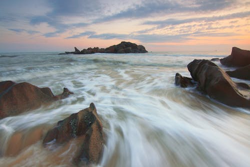 Ücretsiz Gündüz Su Kütlesinin Yakınındaki Kahverengi Kayalar Stok Fotoğraflar