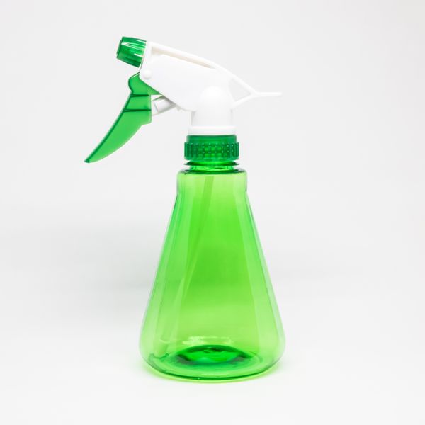 Green plastic mist sprayer on a pale surface — photo by Srattha Nualsate on Pexels