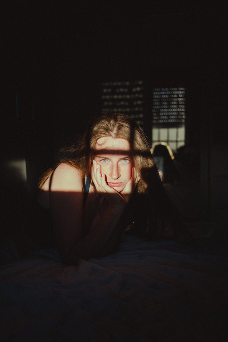 Sunlight On A Woman Holding Her Face In Her Hands