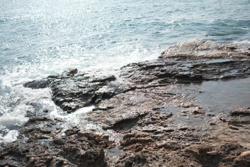 Free A beautiful view of ocean waves crashing against rocky shores in Phe, Thailand. Stock Photo