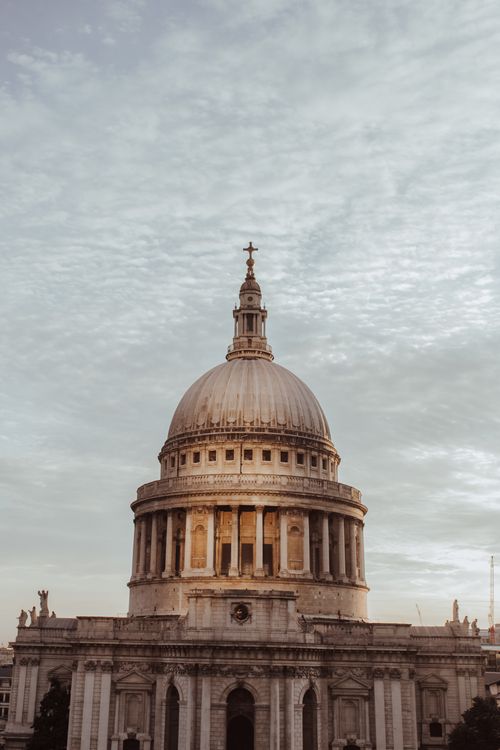 Free St. Paul's Cathedral dome under a dramatic sky with warm lighting, iconic London landmark. Stock Photo