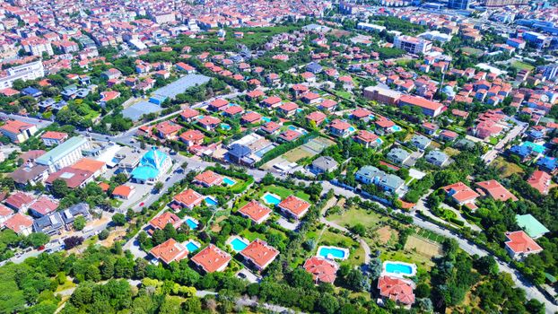 Aerial photo of a suburban area in Istanbul showcasing houses, greenery, and vibrant rooftops.