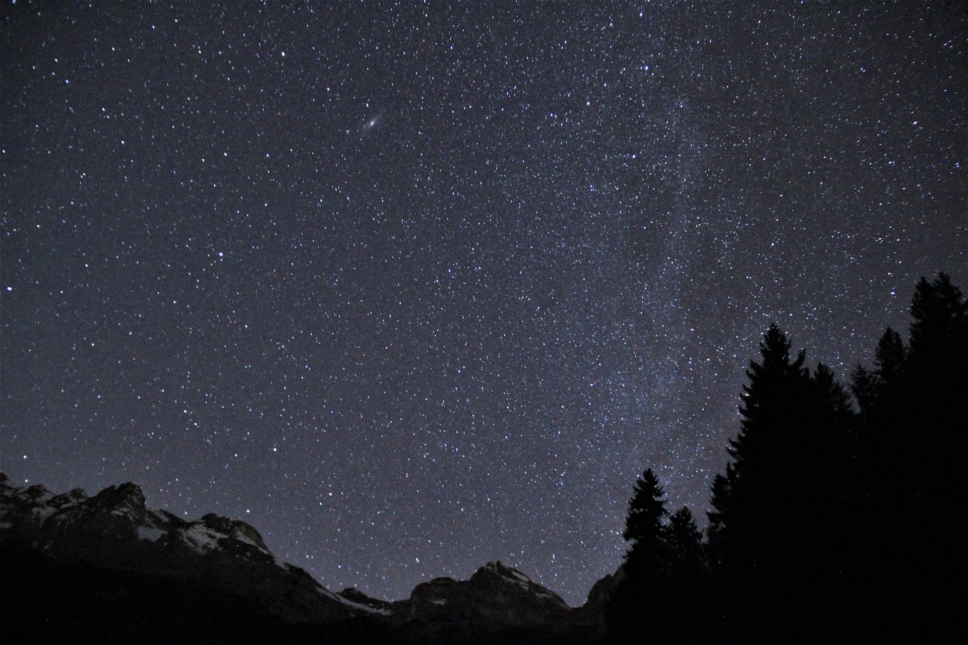 Captivating starry night sky above the alpine landscape in Trento, Italy.