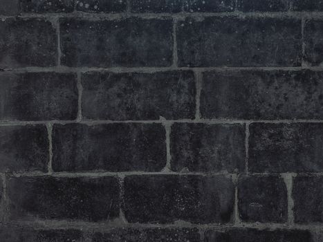 Close-up image of a dark black brick wall showcasing texture and detail.