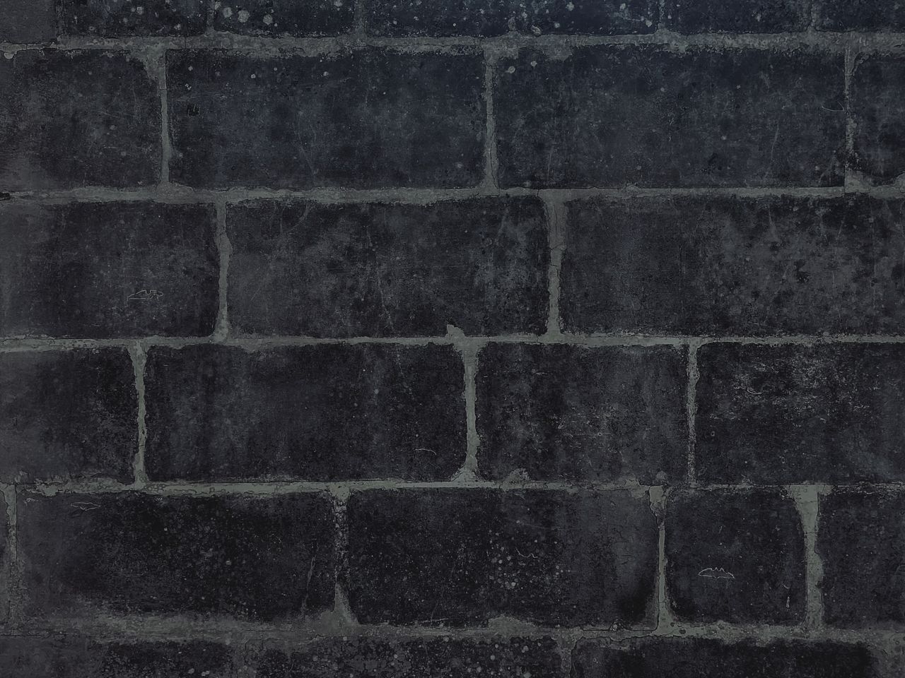 close up image of a dark black brick wall showcasing texture and detai