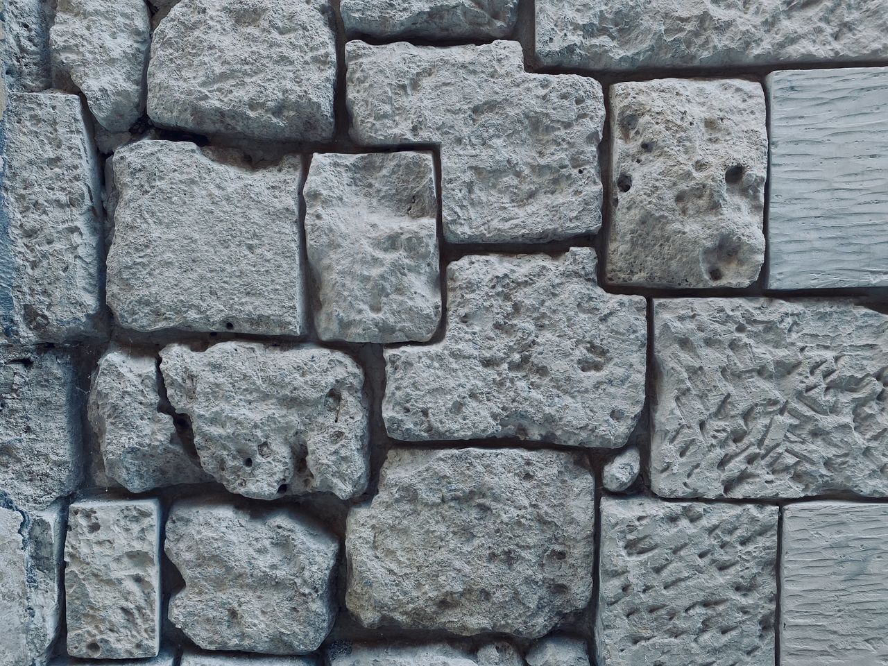close up of a textured stone wall showcasing various shapes and a roug