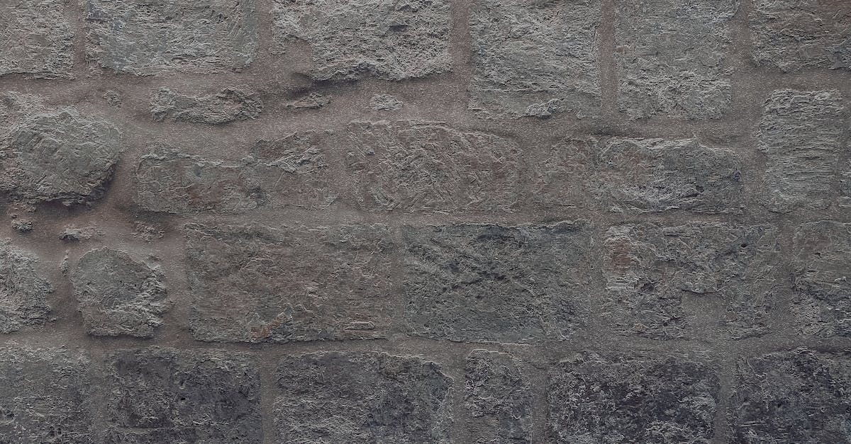 A detailed view of a rugged gray stone wall, showcasing its texture and pattern.