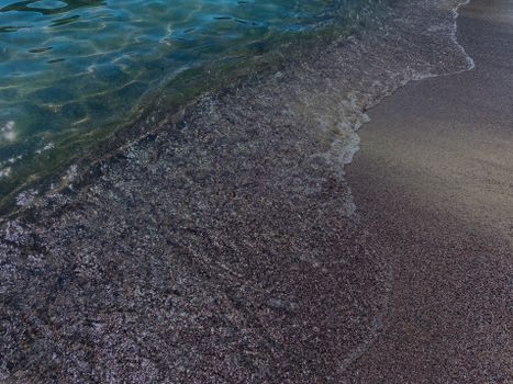 Serene waves gently lapping the sandy shore of a Maltese beach, capturing a peaceful coastal scene.