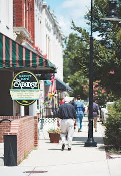 阳光明媚的日子里，人们走过一家时尚的咖啡馆，构成了迷人的城市人行道场景