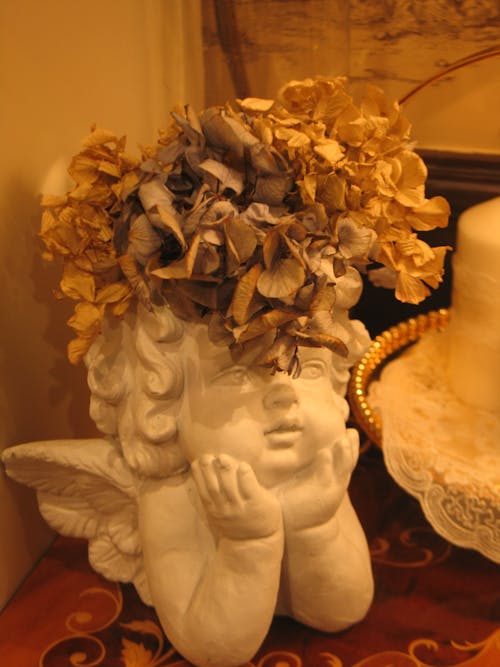 A White Angel Ceramic Figurine With Gold Flower Crown