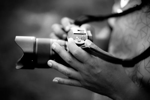 Free Monochrome close-up of hands holding a camera, emphasizing photography art. Stock Photo