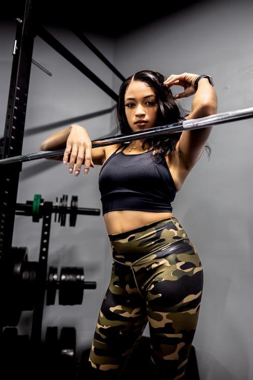 Free Strong woman in activewear posing with gym equipment showcasing fitness and confidence. Stock Photo
