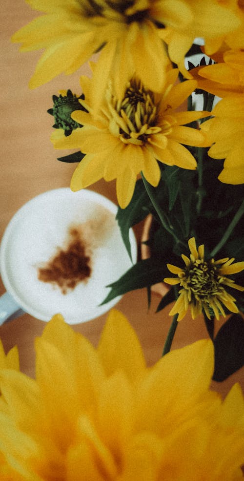 Yellow Flowers Beside the Cup of Coffee