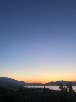 Beautiful twilight scene with mountains and water under a vibrant sky.