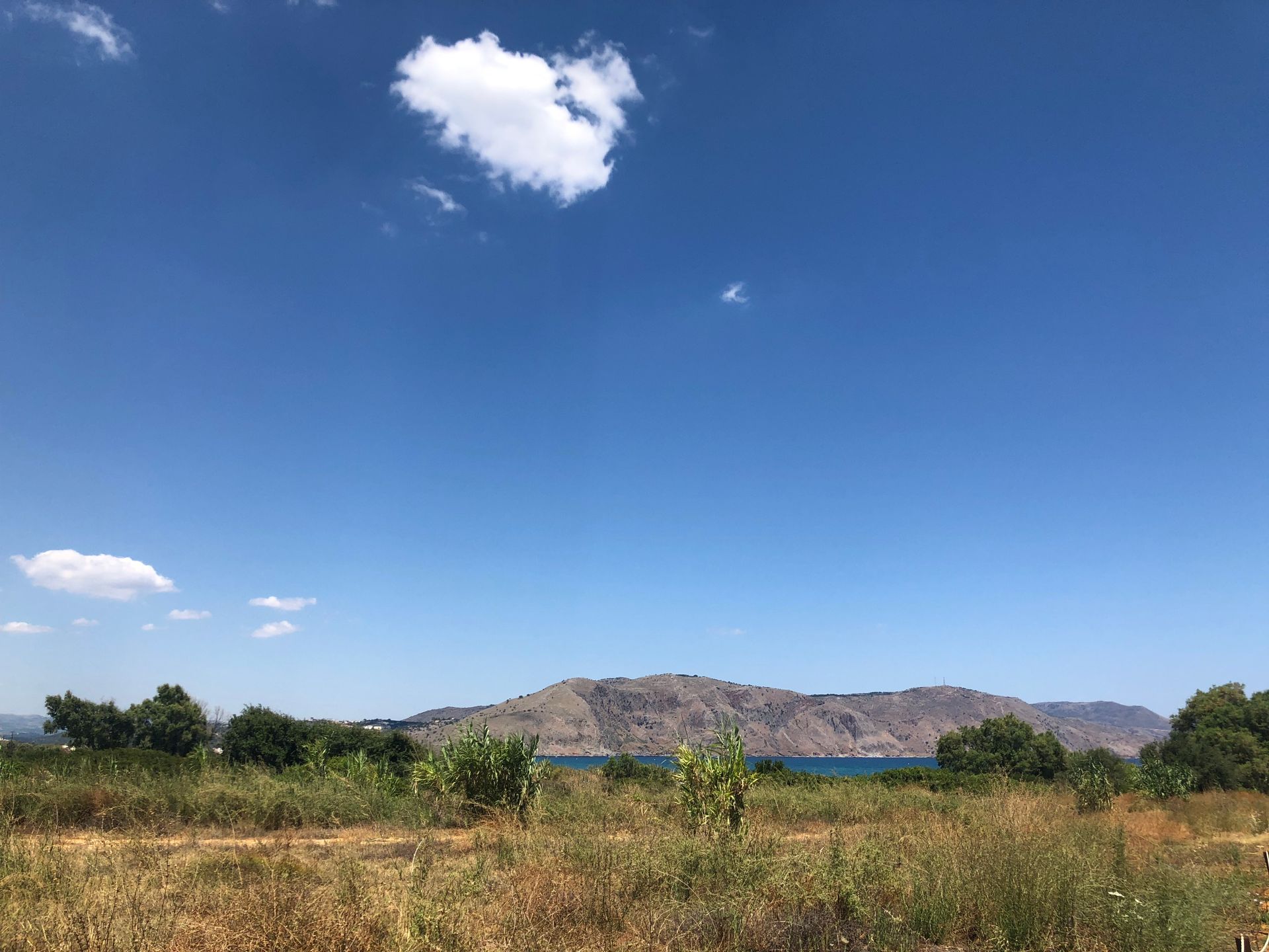 Scenic view of a mountain landscape with clear blue sky and white clouds, perfect for nature lovers.