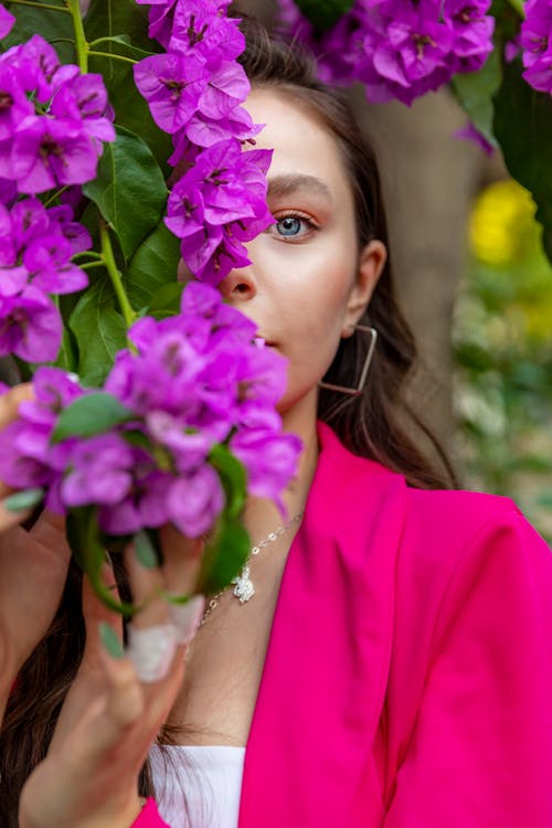 Woman in Pink Blazer Holding Purple Flowers
