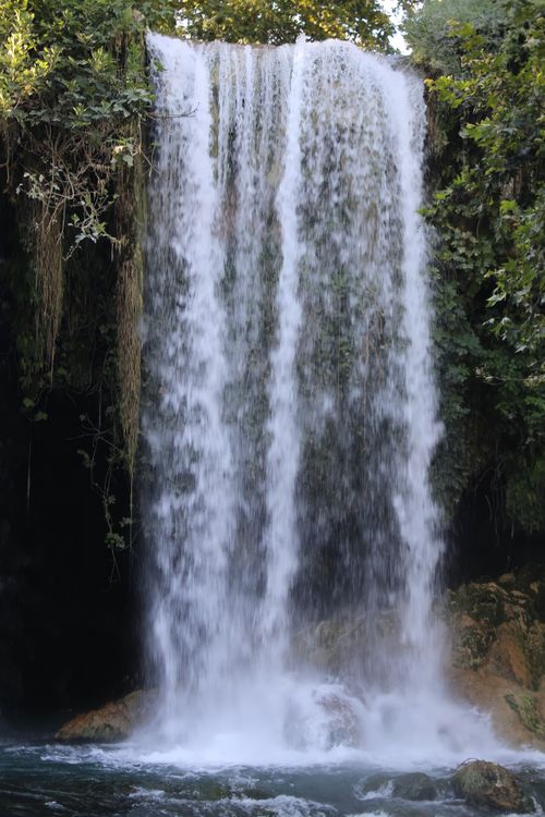 Free A stunning waterfall cascades through dense greenery, captured in motion with a tranquil atmosphere. Stock Photo