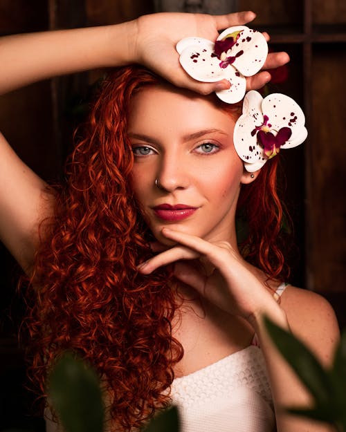 Portrait of Redhead Woman with Orchids in Hair