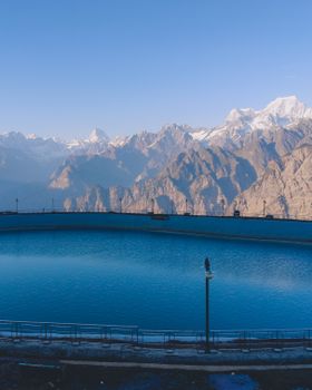 Serene view of Auli Laga Salude reservoir with the Himalayan mountains in the background.
