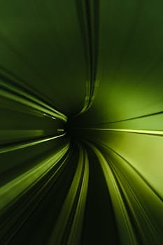 A modern, dynamic abstract view of a tunnel with vibrant green lighting and motion blur creating a futuristic look.