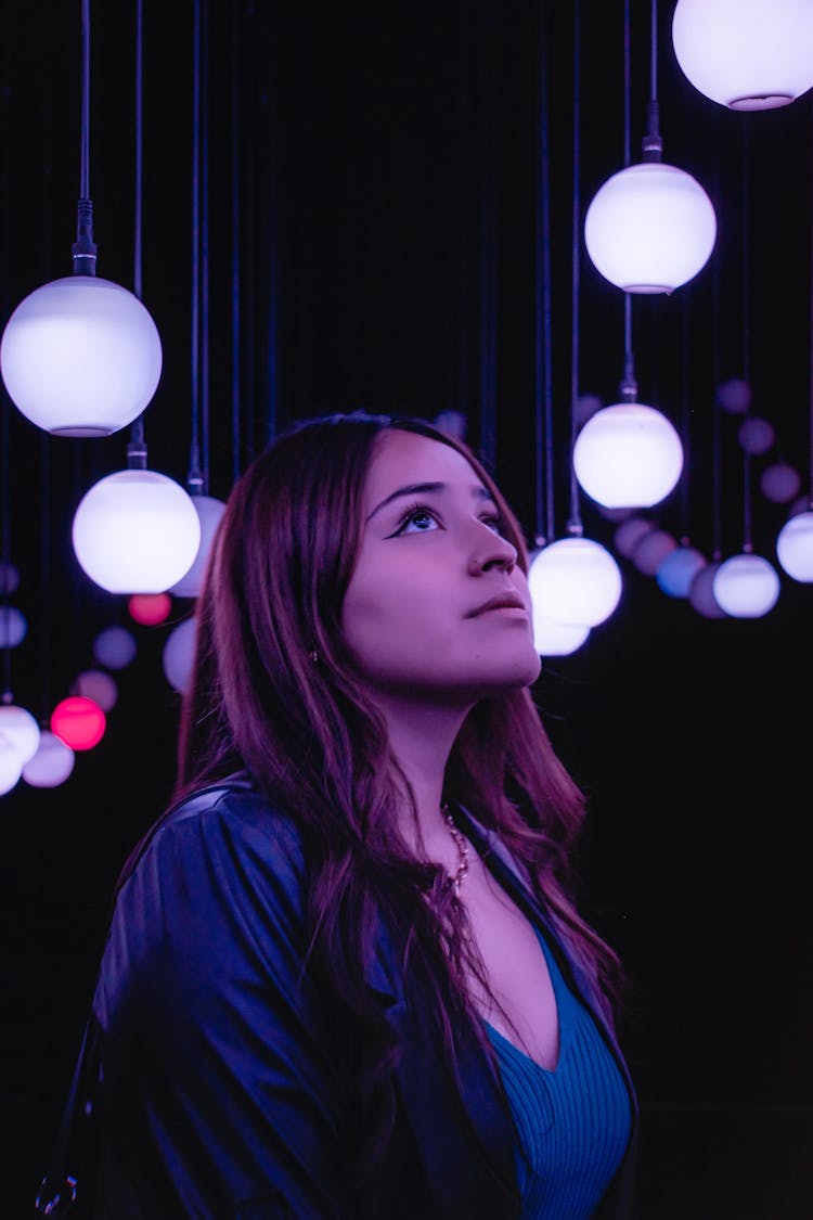 Woman Looking At Hanging Lights