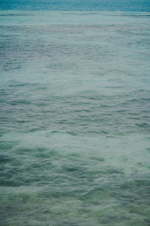 Free Capture of gentle turquoise ocean waves creating a peaceful and calming atmosphere. Stock Photo