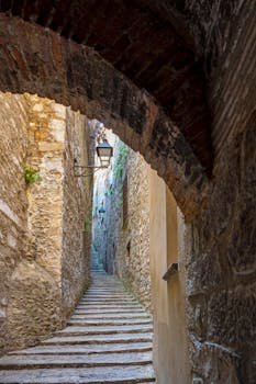 Discover the narrow stone pathway through a historic alley in Gerona, Spain.