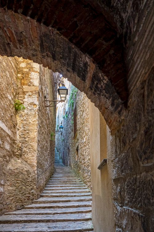 Free Discover the narrow stone pathway through a historic alley in Gerona, Spain. Stock Photo