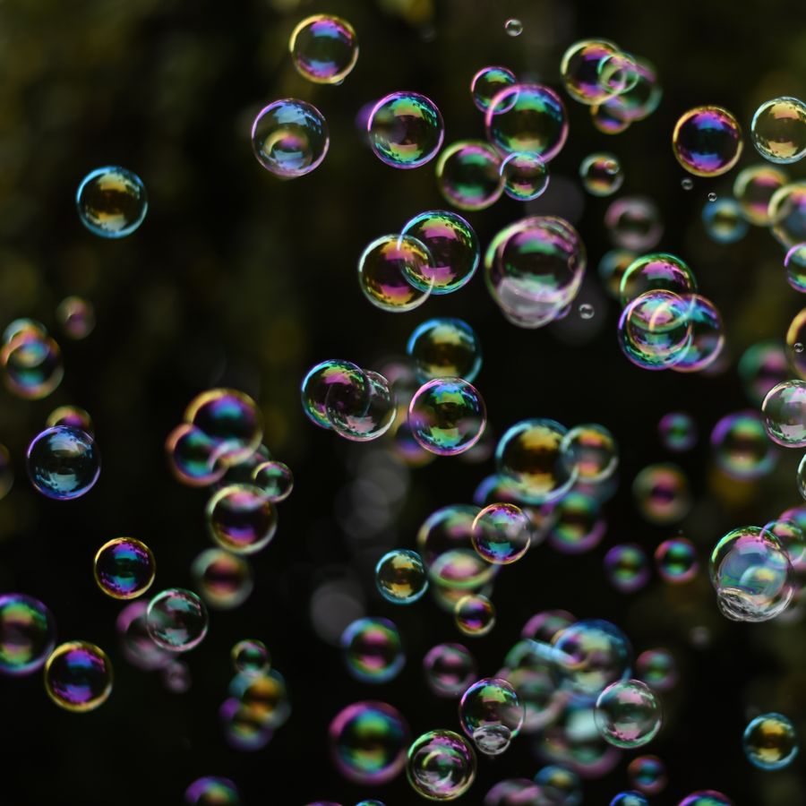 Iridescent bubbles drifting in a dark room — photo by Alexas Fotos on Pexels