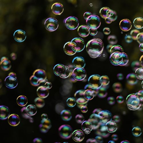 Free Vibrant soap bubbles floating freely in dark atmospheric setting. Stock Photo