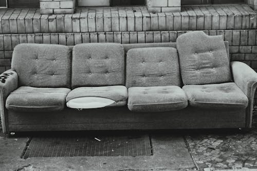 Grayscale Photo of an Abandoned Couch