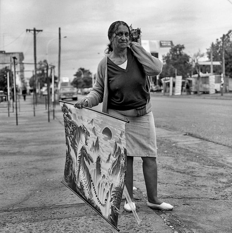 Elderly Woman Selling A Poster