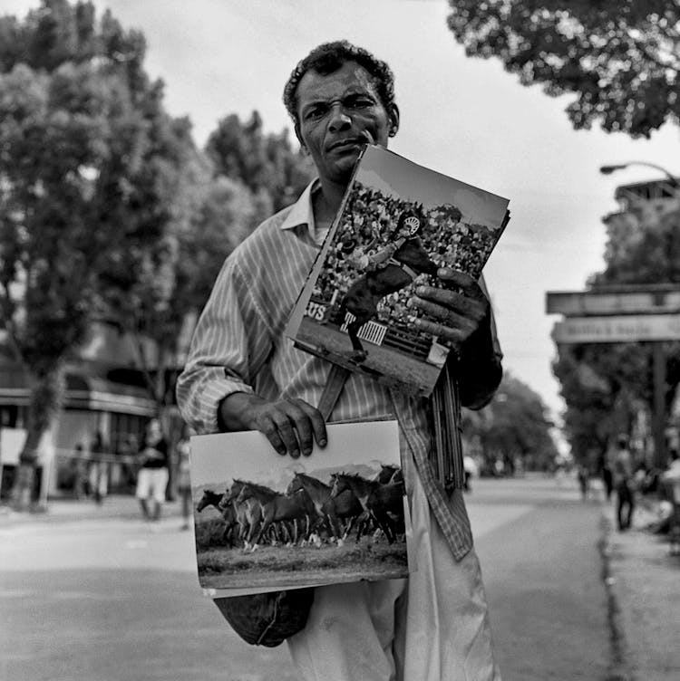 Elderly Man Holding Posters On A Street In Black And White 