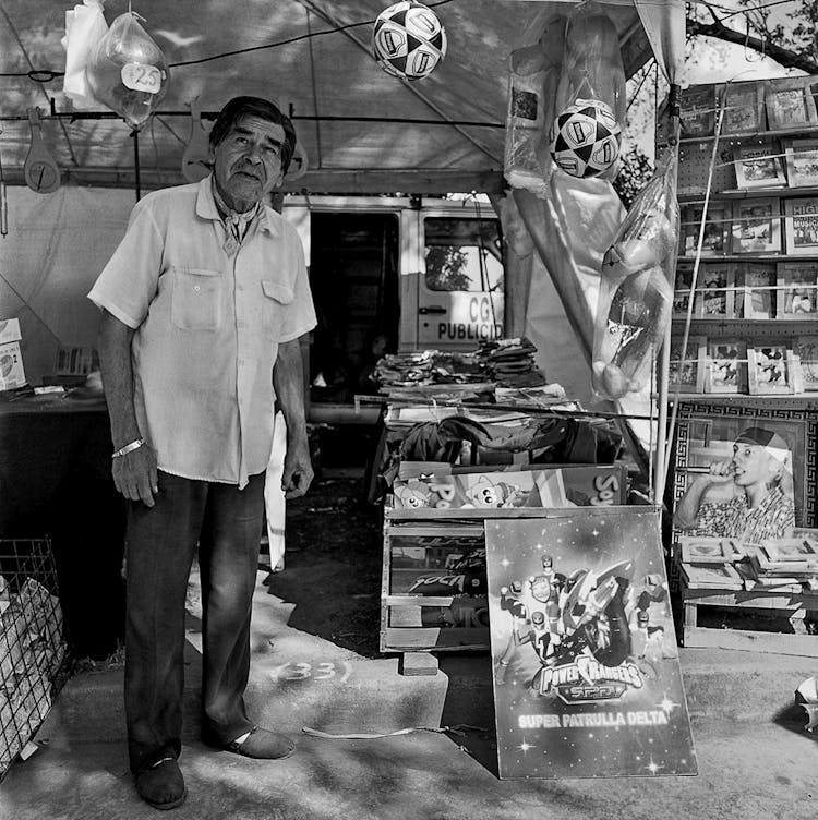 Elderly Man Selling Souvenirs On A Street In Black And White 