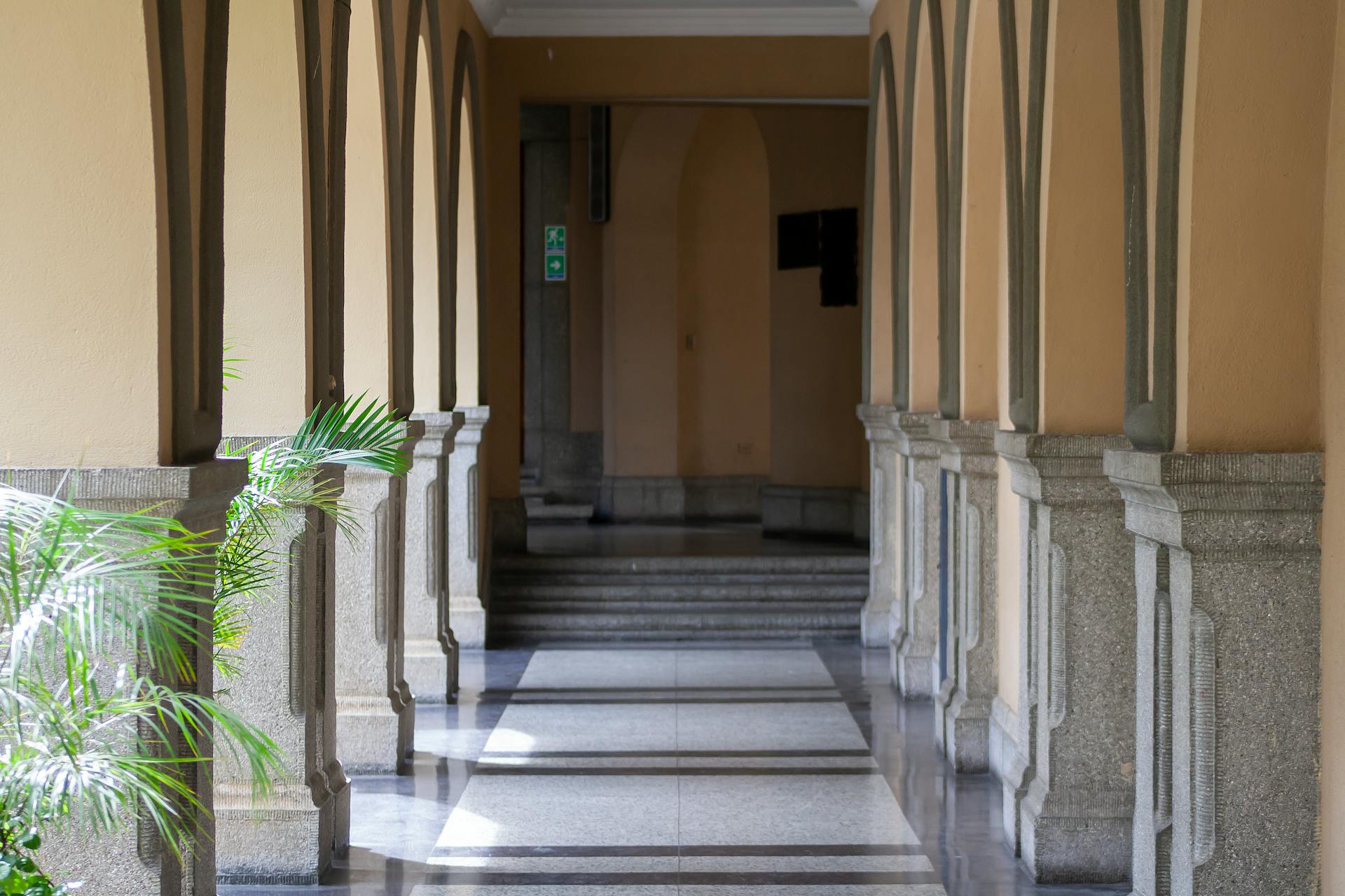 Sunlit colonial corridor in Venezuela with arches and columns casting beautiful shadows.