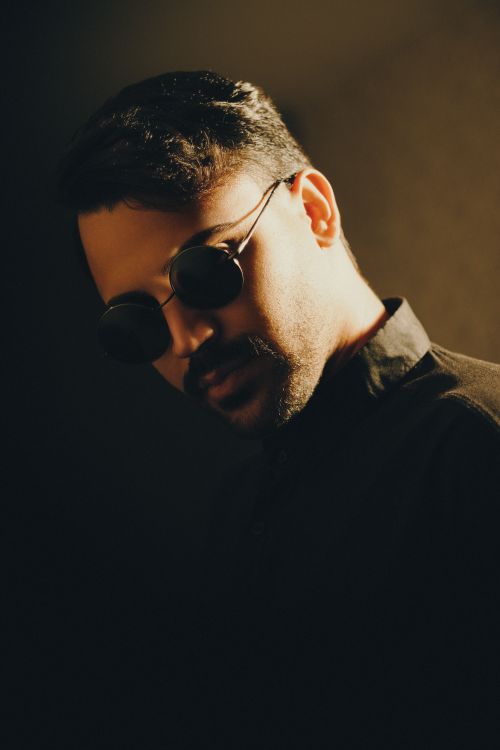 Free A striking portrait of a man wearing sunglasses, emphasizing style and mood. Stock Photo