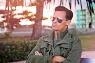 一位时尚男士戴着太阳镜，在户外捕捉凉爽的城市氛围