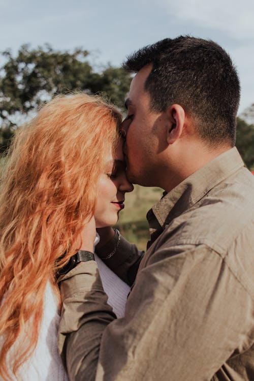 Close Up Photo of Man Kissing a Woman