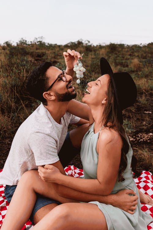 Man and Woman Eating Grapes Together