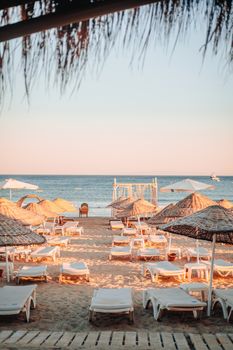 A tranquil seaside view with sun loungers and umbrellas on a sunny summer day.