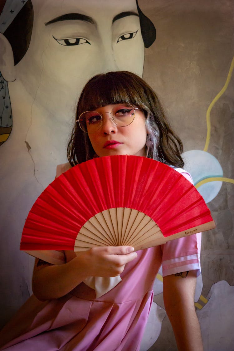 Woman Holding Fan And Wearing Eyeglasses