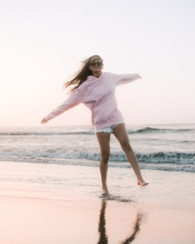 A carefree woman frolics along the beach at sunset in Puerto Colombia, capturing a sense of freedom and joy.