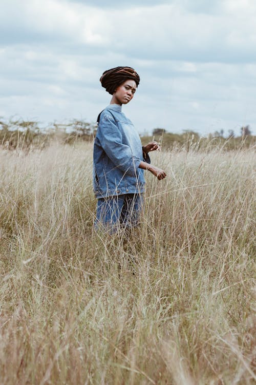 Woman Standing on Green Grass Field