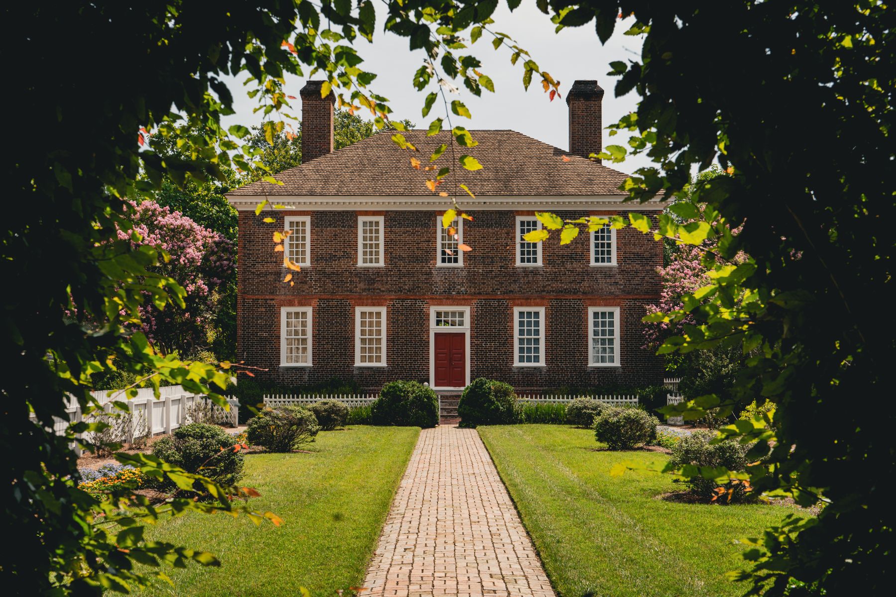 Historic brick house in Williamsburg, Virginia, with a pitched roof and brick chimneys.