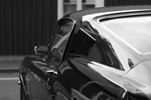 Capture of a vintage Ford Mustang in reflective black and white tones on a street in Sweden.