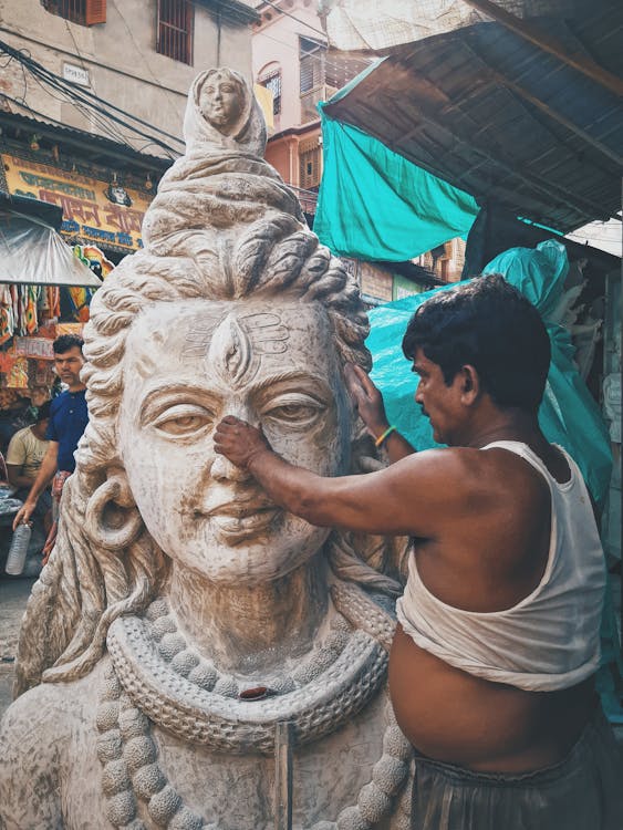 A Man Holding a Statue's Nose