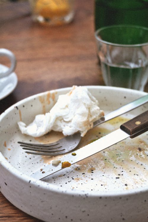 A Close-Up Shot of a Knife and a Fork on an Empty Plate