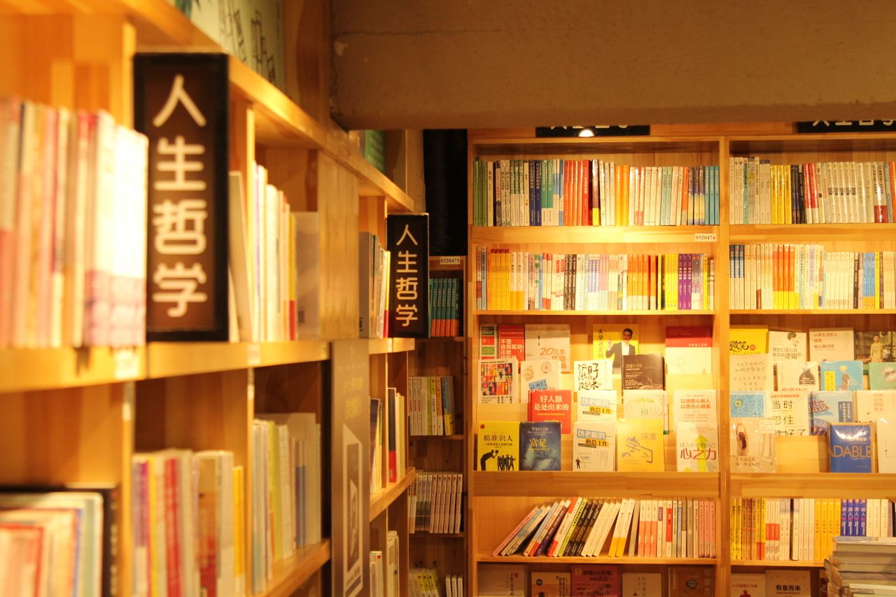 warmly lit bookshelves with diverse genres in a quiet library setting